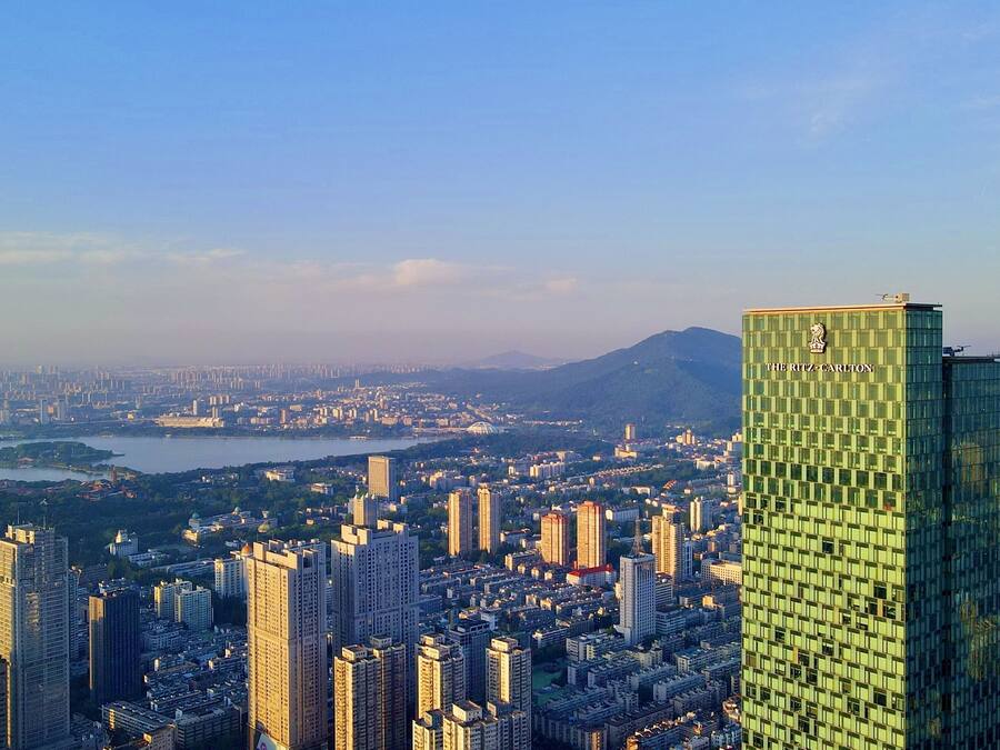 Un hotel de gran altura con una fachada verde distintiva y el nombre 'The Ritz-Carlton' en la parte superior.