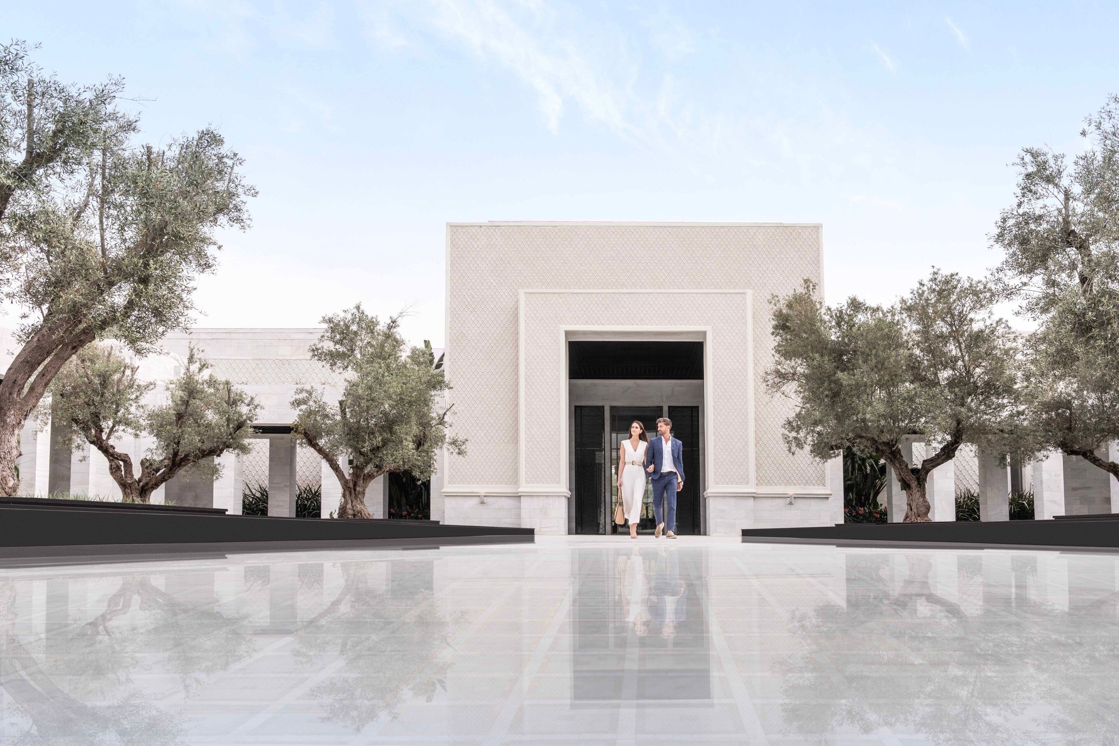 A modern building with a reflective floor and a large entrance.