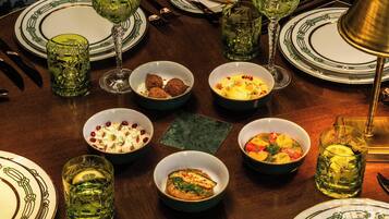 Una mesa de comedor dispuesta con diferentes platos, vasos y cubiertos.