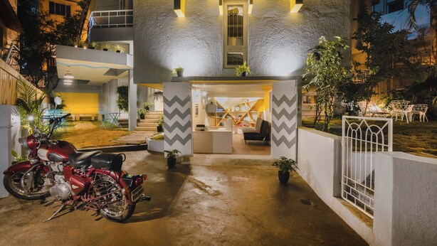 Un edificio moderno con una entrada central, una recepción y una motocicleta estacionada afuera.