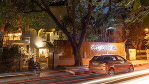 Un hotel ZOSTEL con diseño moderno, una entrada visible y un coche aparcado delante.