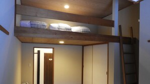 Una habitación japonesa tradicional con suelo de tatami, techo de madera y puertas correderas.
