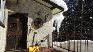 Un edificio de ladrillo con techo nevado y una reja metálica.