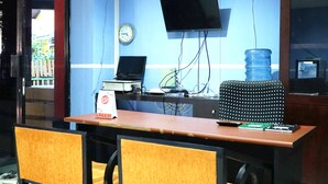 Un comptoir d’accueil équipé d’un ordinateur, d’une horloge et d’un distributeur d’eau.
