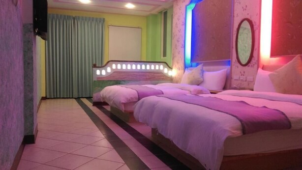 Una habitación de hotel con una cama grande, un espejo de tocador y una cortina.