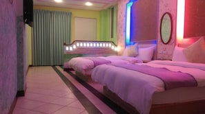Una habitación de hotel con una cama grande, un espejo de tocador y una cortina.