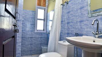 A bathroom with a toilet, sink, and shower curtain.