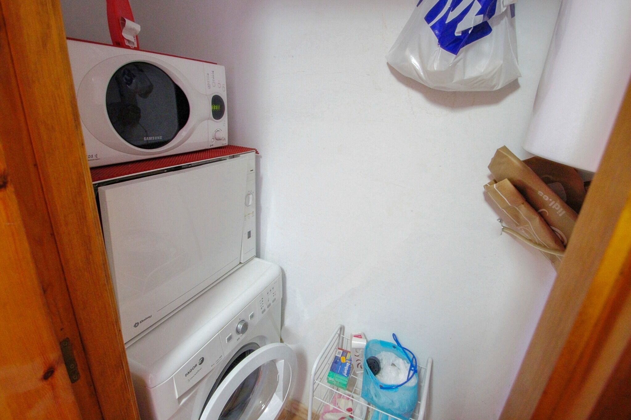 Un espace buanderie équipé d’un lave-linge, d’un sèche-linge et d’un four à micro-ondes.