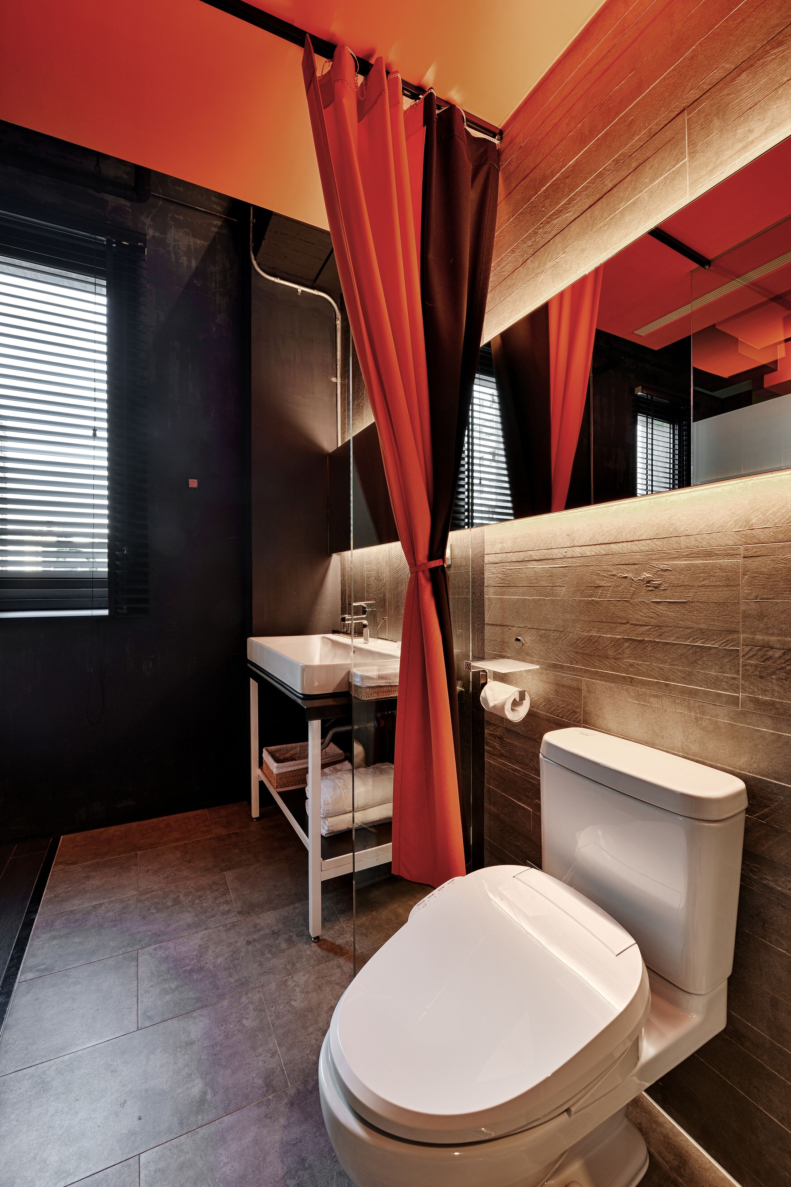 A modern bathroom with a white toilet, a sink, and a mirror.
