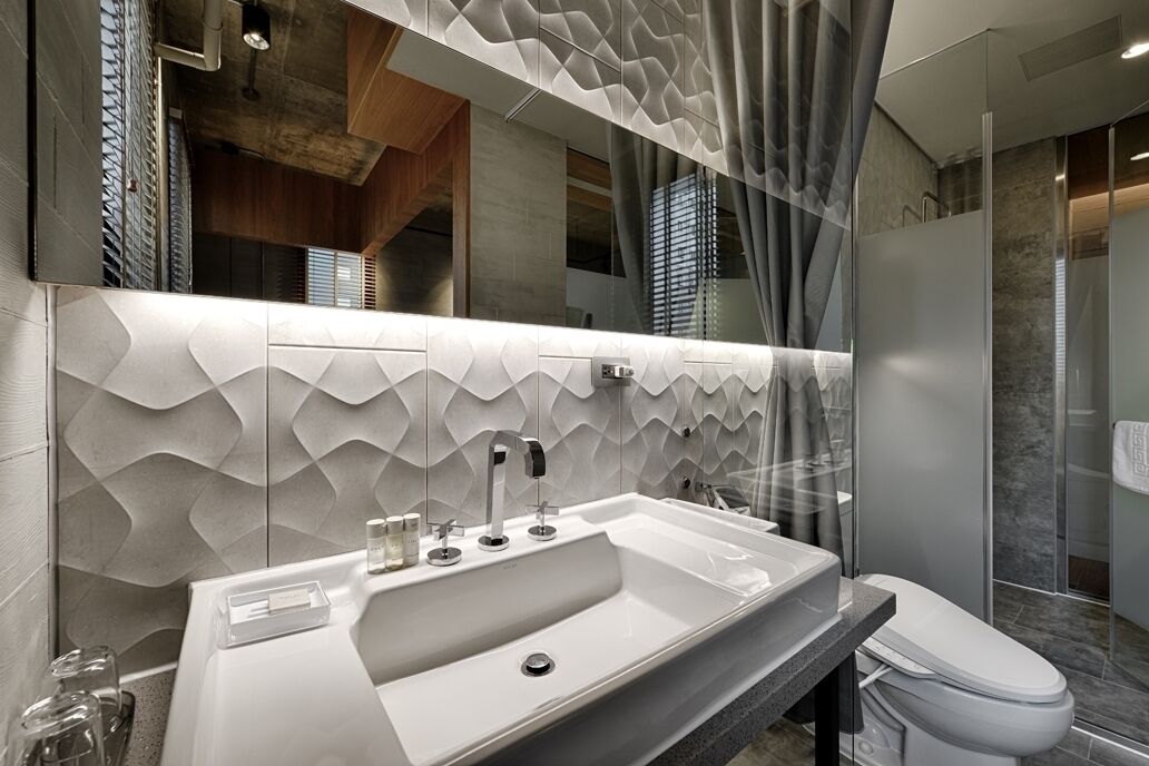 Une salle de bain moderne avec un grand lavabo, un miroir et un espace douche.