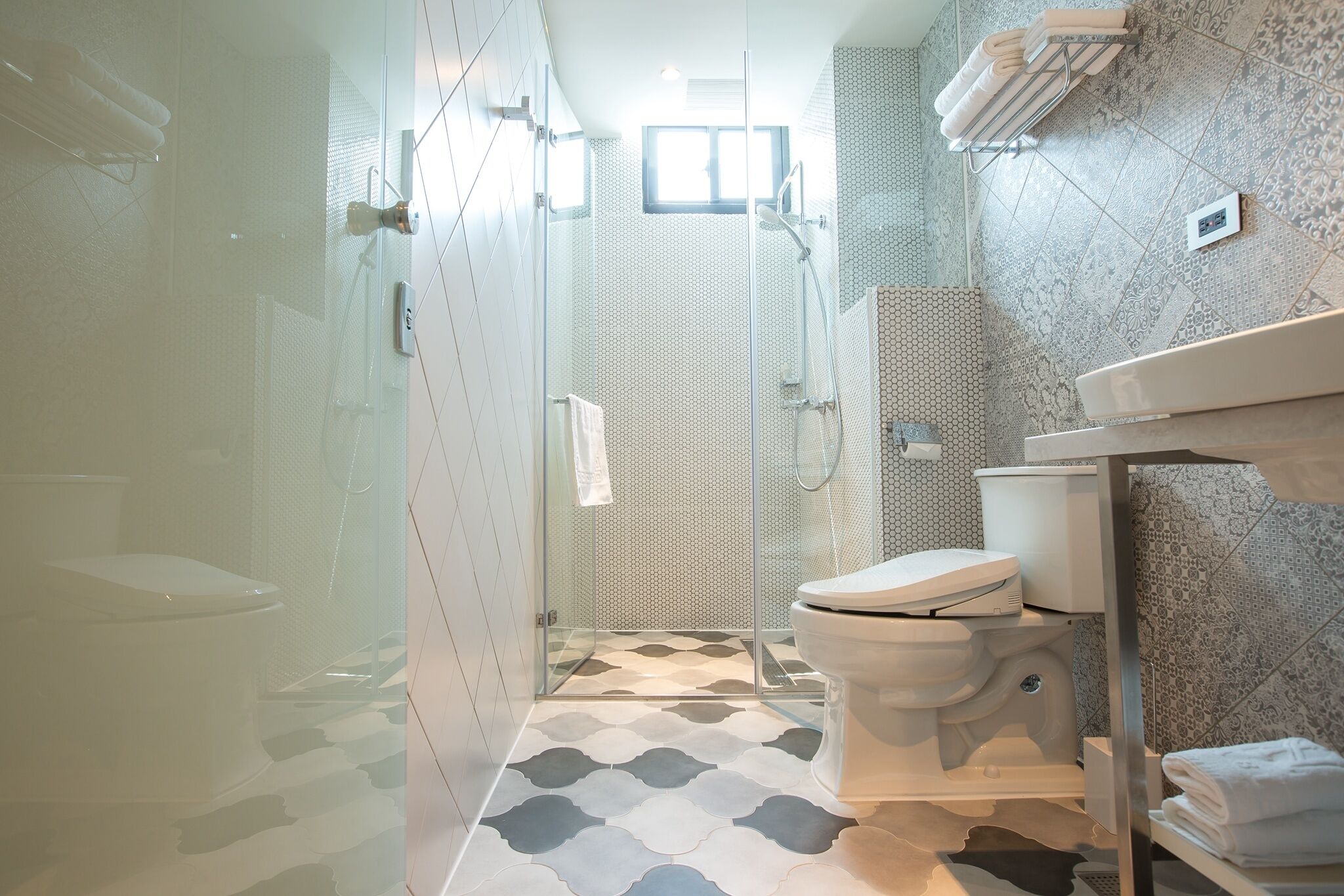 Un baño moderno con ducha de vidrio, inodoro y zona de lavamanos.