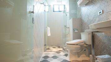 Un baño moderno con ducha de vidrio, inodoro y zona de lavamanos.