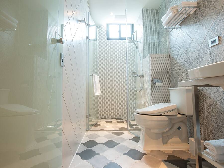 Un baño moderno con ducha de vidrio, inodoro y zona de lavamanos.