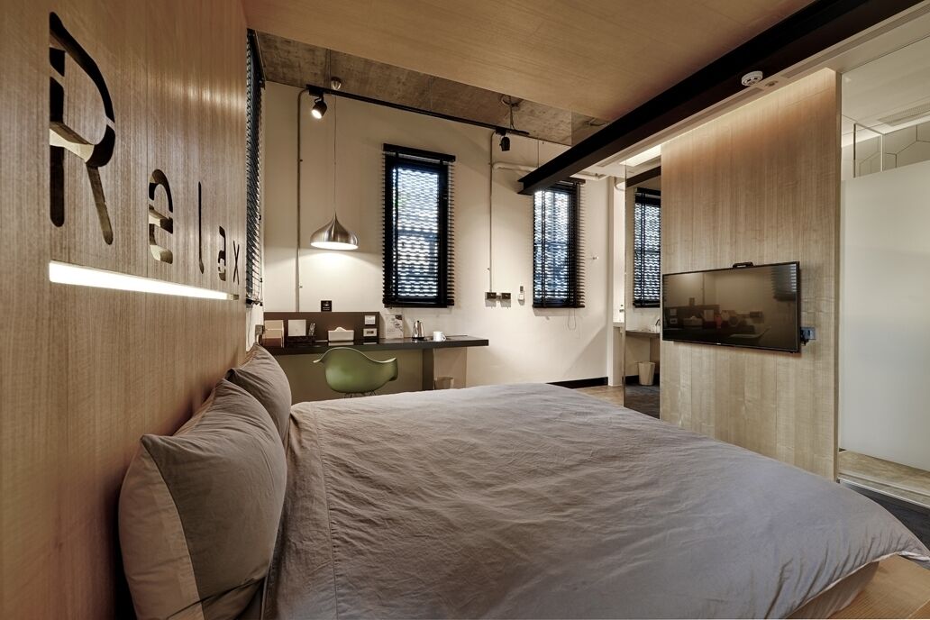 Une chambre à coucher moderne avec un grand lit, un bureau et une télévision.