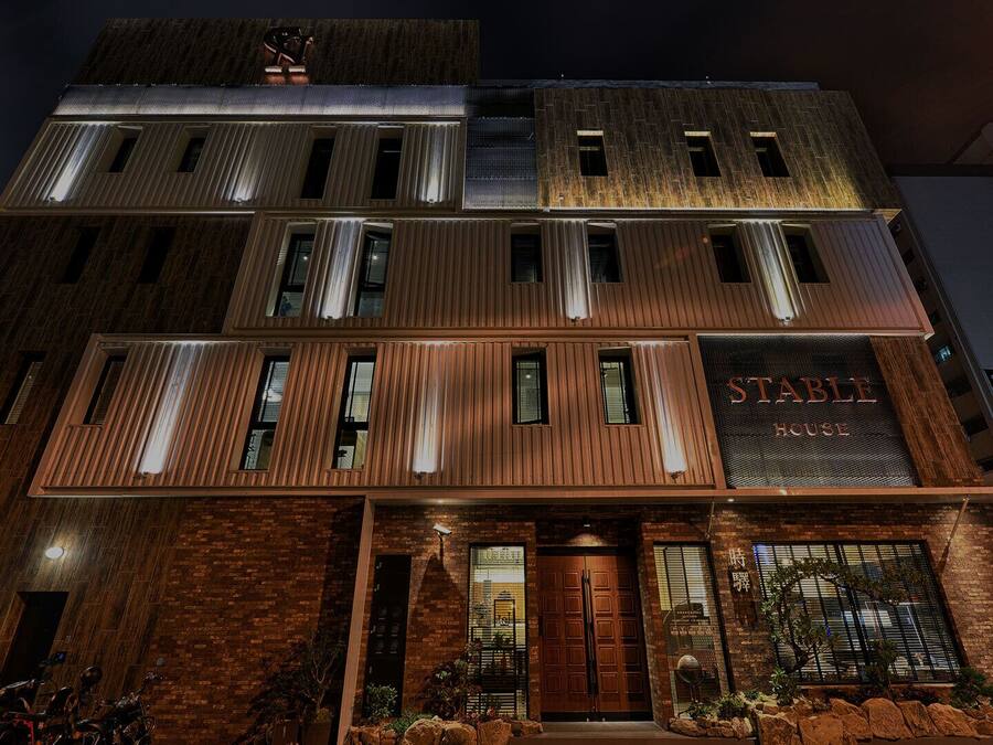 Un edificio de varios pisos con un letrero destacado que dice "STABLE HOUSE".