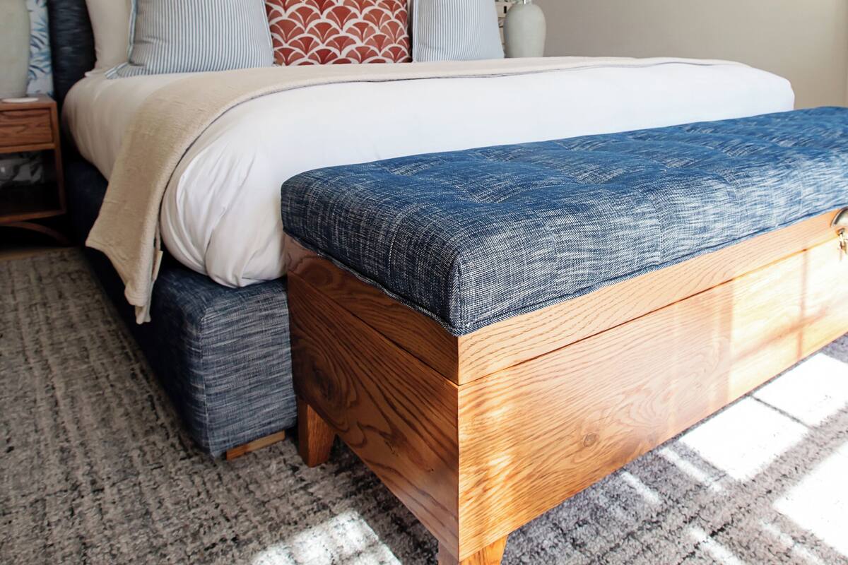 A bedroom with a bed, bedside tables, and a patterned wall.