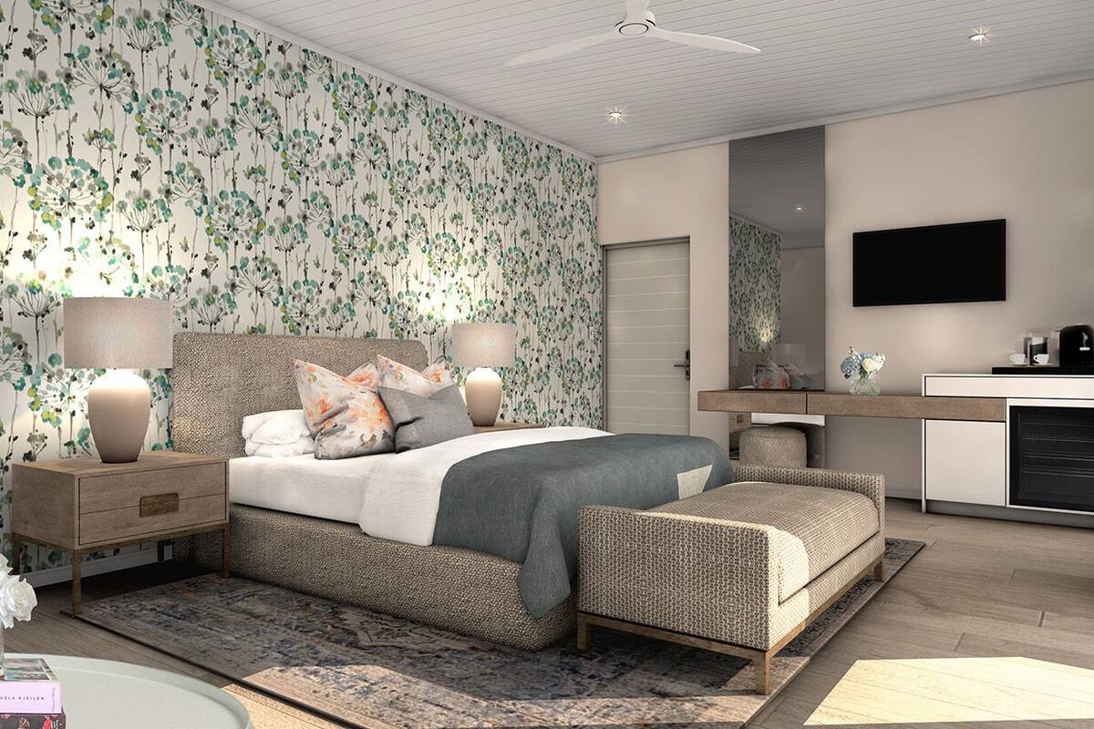 A modern bedroom with a large bed, bedside tables, a flat-screen TV, and a built-in desk.
