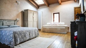 Una camera da letto con soffitto in legno, un letto grande, un armadio e un termosifone.