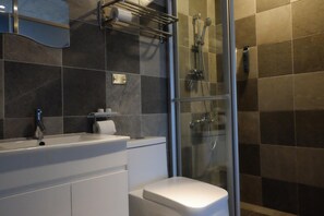 A modern bathroom with a glass shower enclosure, a white sink, and a toilet. - CoffeeLoft Inn &  Café (Taitung)