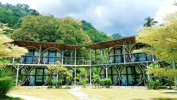 Um edifício moderno com grandes janelas em arco e uma área externa coberta.