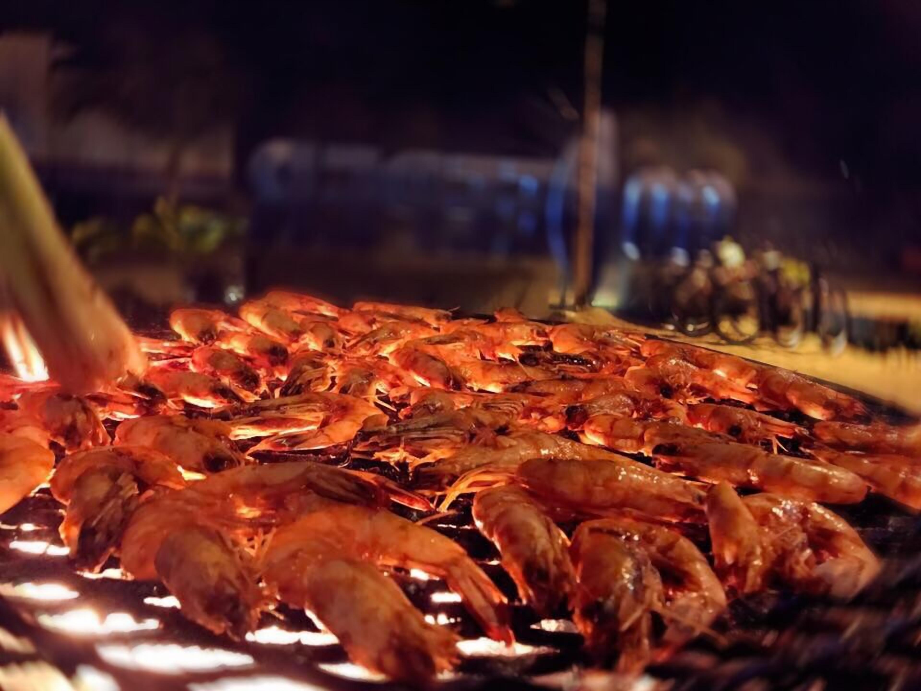 A grill with cooked shrimp.