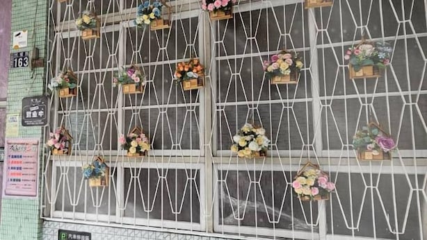 A wall with multiple flower arrangements in window boxes. - Huan Tai Hotel (Shuili)