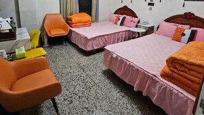 A hotel room with two beds, a chair, a small table, and a wall-mounted phone. - Huan Tai Hotel (Shuili)
