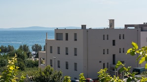A multi-story building with a flat roof, several windows, and a satellite dish. - Luxury Rooms near Beach (Split)