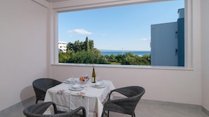 A balcony with a table set for two, overlooking a sea view. - Luxury Rooms near Beach (Split)