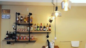 A kitchen with shelves of bottles, a clock, and a hanging light fixture. - Ching Yu Rou B&B (Dongshan)
