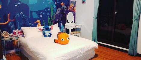 A bedroom with a bed, a nightstand, a mirror, and a wall mural.