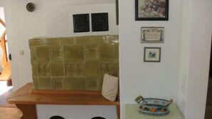 Une pièce avec un banc, un mur recouvert de carreaux et une petite table sur laquelle se trouve un bol décoratif.