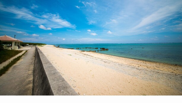 A beach with a concrete walkway and a small building with a tiled roof. - Seaside Tellme Ishigakizima (Ishigaki)
