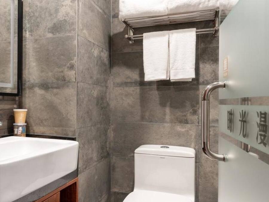 Un baño moderno con un lavabo blanco, inodoro y zona de ducha.