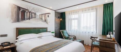 A hotel room with a large bed, a desk, a chair, a TV, and a painting on the wall.