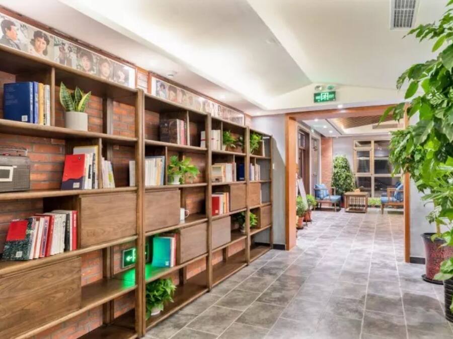 A library with bookshelves and potted plants.