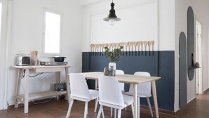 Una cocina moderna con una mesa de comedor, sillas, estufa y una lámpara colgante.