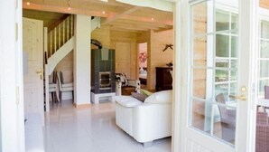 Ein modernes Wohnzimmer mit einem weißen Sofa, einem Kamin und einer Treppe, die zu einer anderen Ebene führt.