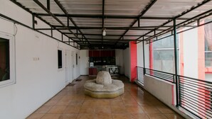 Un pasillo con suelo de baldosas, una zona de estar central y una cocina al fondo.