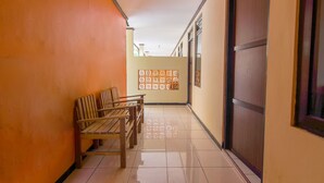 A corridor with a wooden bench, a decorative screen, and a sliding door.