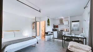 A modern hotel room with a bed, a dining area, and a kitchen. - Studio Wood Nature & Confort 3* Wifi+Parking (Laveyron)