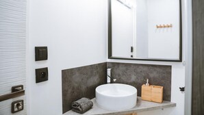 A modern bathroom with a white sink, a large mirror, and a towel on the counter. - Studio Wood Nature & Confort 3* Wifi+Parking (Laveyron)