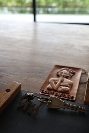 Una mesa de madera con una placa de madera tallada, una llave y un llavero.