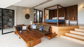 A modern living room with a wooden coffee table, a sofa with patterned cushions, and a large window. - Leceb Sesoko Villa (Motobu)