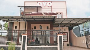 Ein Gebäude mit einem auffälligen 'OYO'-Schild, einem überdachten Eingang und einer befestigten Auffahrt.