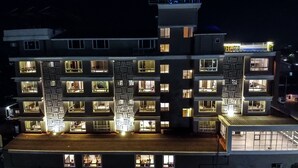 Un hotel de varios pisos con ventanas iluminadas y un patio central.