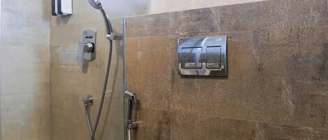 Une salle de bain moderne avec une douche à parois de verre, des toilettes et un porte-serviettes.