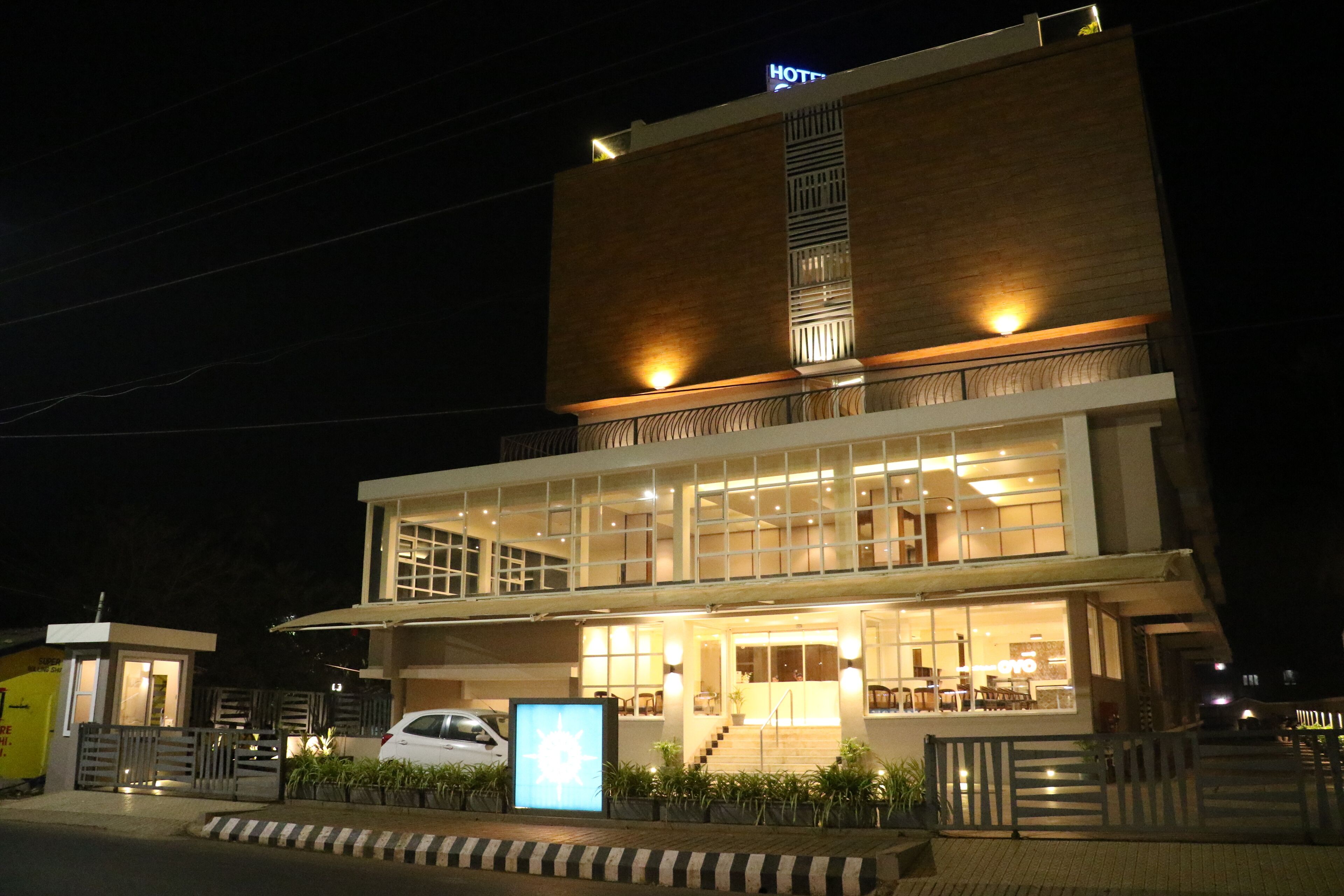 Hotel de dois andares com design moderno, apresentando uma entrada ampla e uma escadaria visível que leva ao andar superior.