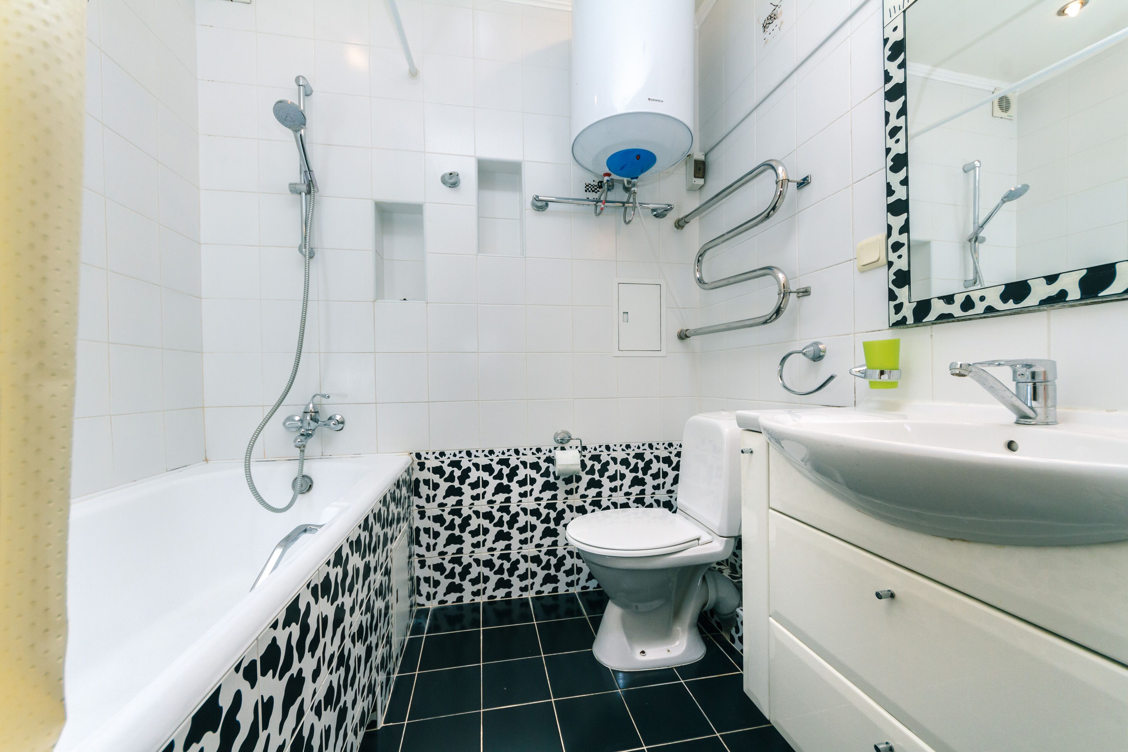 A bathroom with a bathtub, toilet, sink, and mirror.
