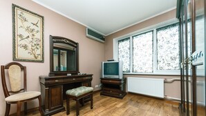 A room with a wooden dresser, a chair, a television, and a window with floral curtains. - Apartment on Cheliabinska 19 (Kyiv)